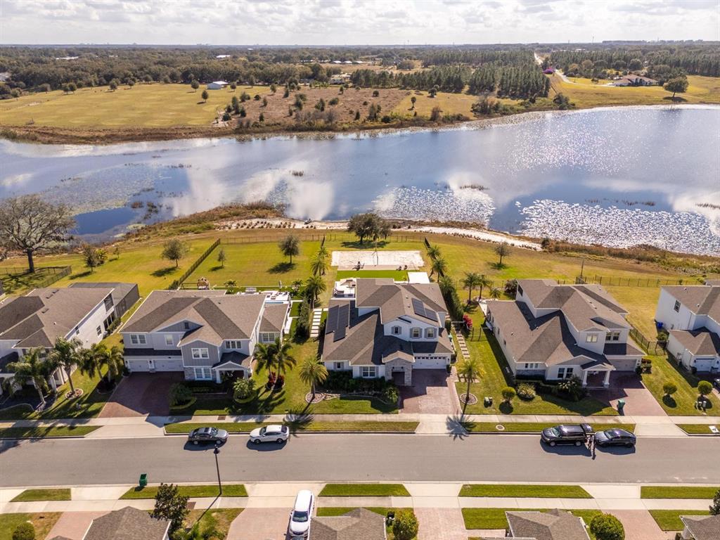An aerial view shows a row of suburban houses situated along a lake — 16870 SANCTUARY DRIVE, WINTER GARDEN, FL