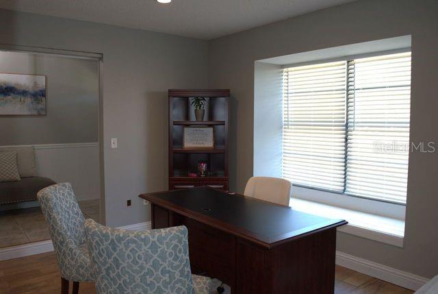 A home office features a dark wood desk, patterned chairs, and a large window — 3486 HAWKIN DRIVE, KISSIMMEE, FL