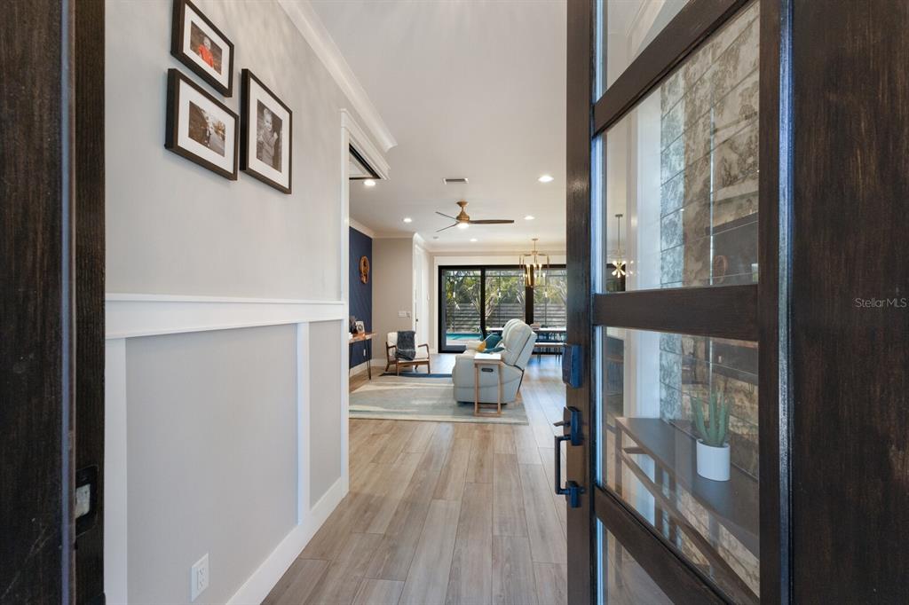 A view from an entryway looking into a living room with wood-look flooring and furniture — 2823 MARSHALL DRIVE, SARASOTA, FL