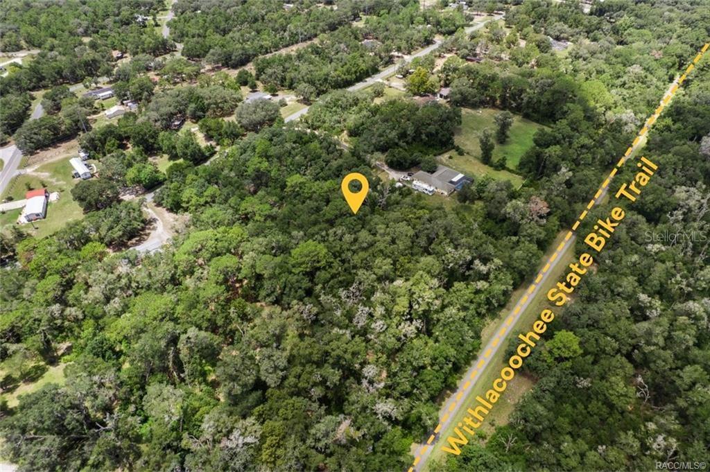An aerial view shows a wooded lot adjacent to the Withlacoochee State Bike Trail — 4855 N HIGHLAND PARK DRIVE, HERNANDO, FL