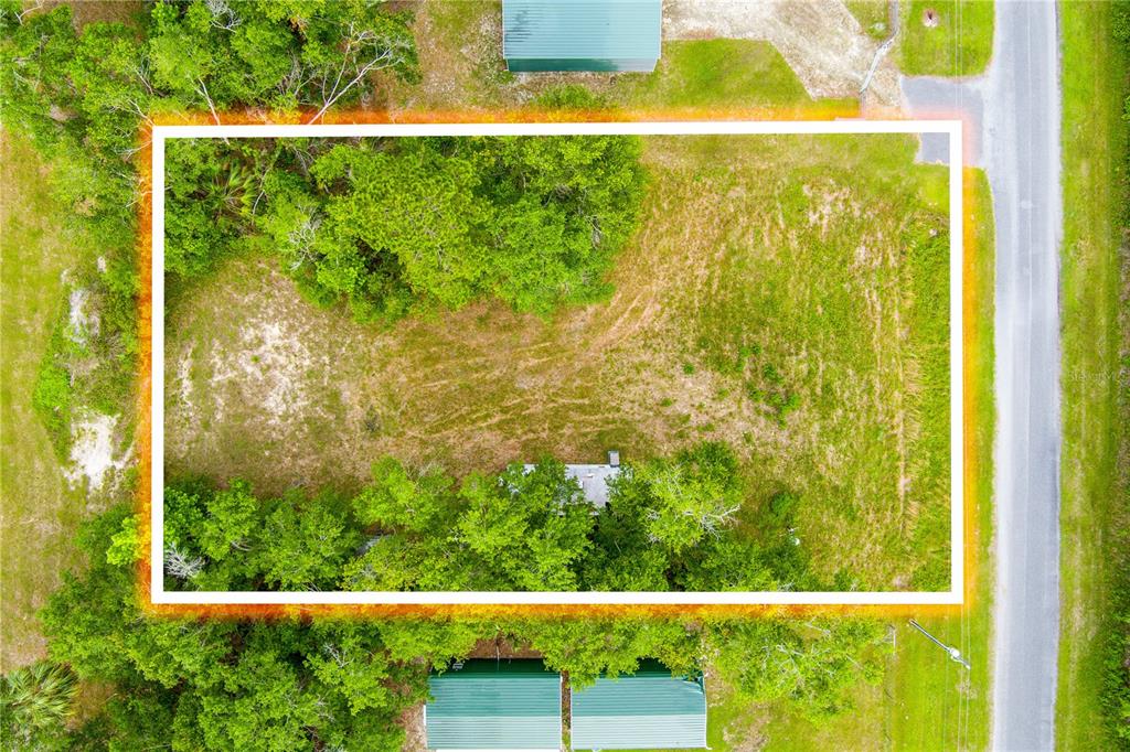 An aerial view shows a rectangular plot of land with trees and a small structure — 400 COASTAL OAK LANE NW, STEINHATCHEE, FL