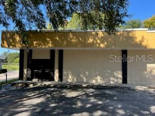 A single-story commercial building with a tan brick facade and a yellow upper trim — 1830 NE 2ND STREET UNIT 1, GAINESVILLE, FL