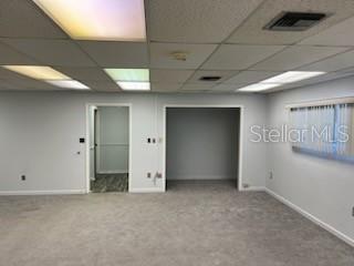 An office space with gray carpeting, a drop ceiling, and two doorways leading to other rooms — 1830 NE 2ND STREET UNIT 1, GAINESVILLE, FL