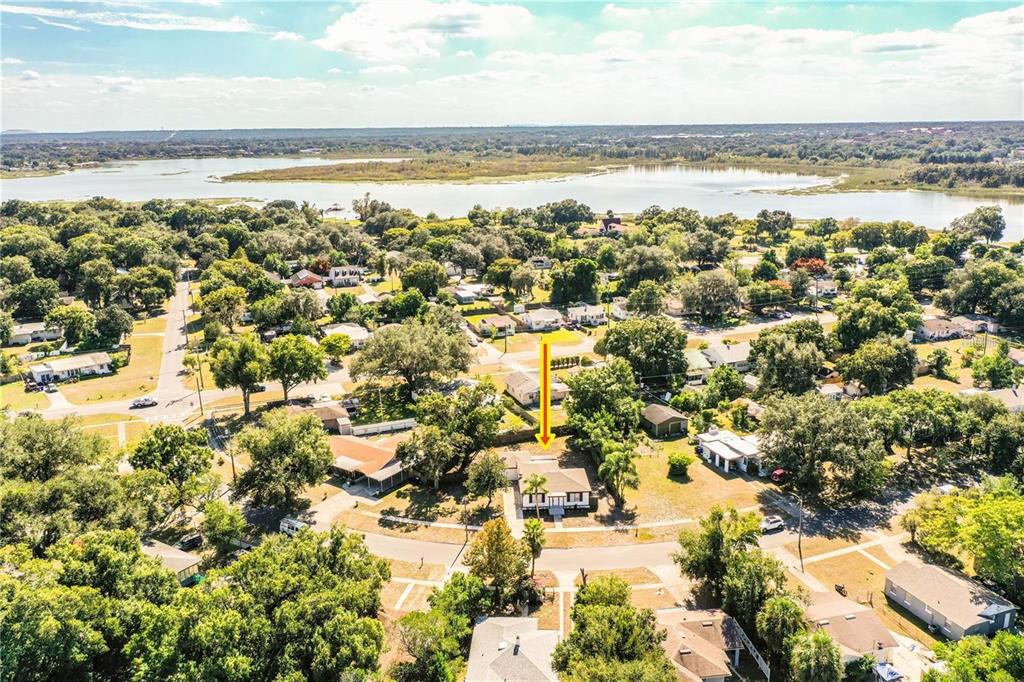 An aerial view shows a single-story house with a yellow arrow pointing to its roof — 1851 E ELM ROAD, LAKELAND, FL