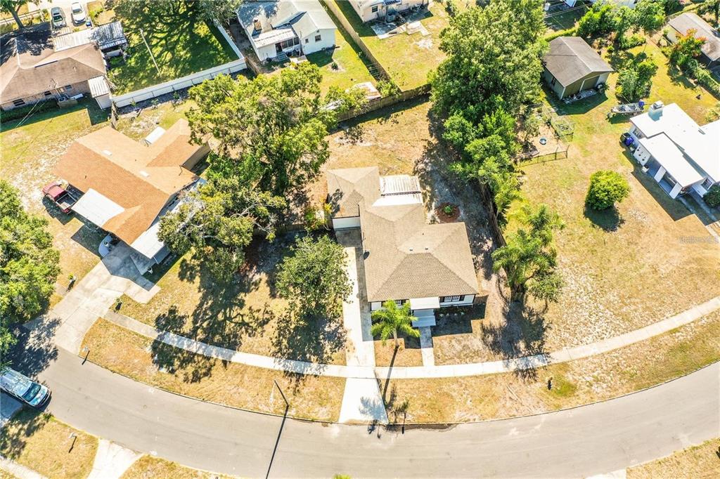 An aerial view shows a residential house with a brown roof and a paved driveway — 1851 E ELM ROAD, LAKELAND, FL