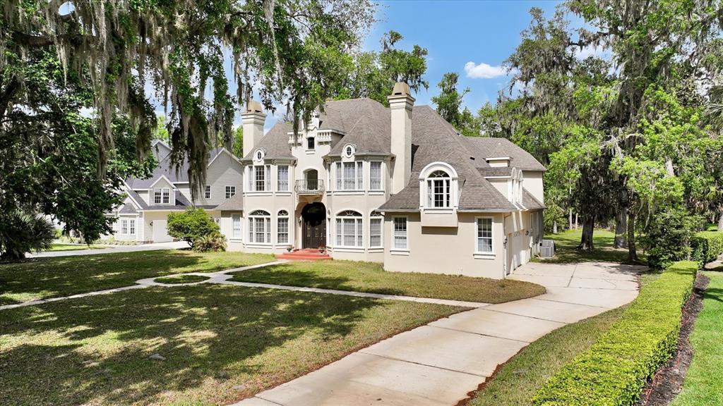 A two-story stucco house with a shingled roof, arched entryway, and a concrete driveway — 48 AUDUBON LANE, FLAGLER BEACH, FL