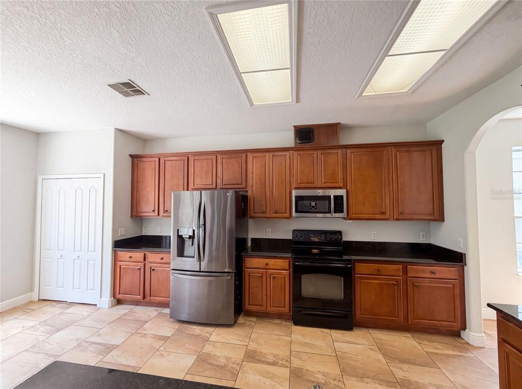 An interior view shows tiled floors, arched doorways, and a white closet door — 12706 GROVEHURST AVENUE, WINTER GARDEN, FL