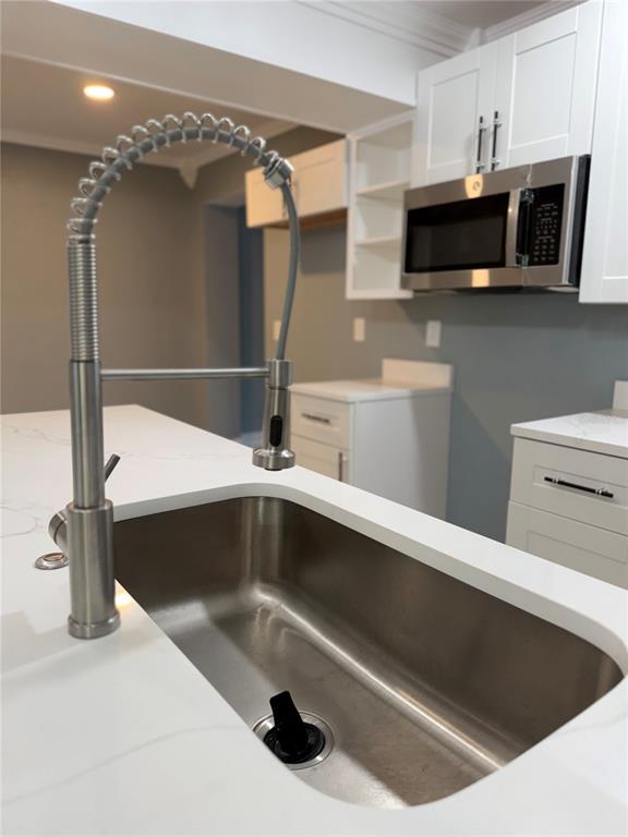 A modern kitchen features white cabinets, stainless steel appliances, and a central island with seating — 682 DURANGO WAY, ALTAMONTE SPRINGS, FL