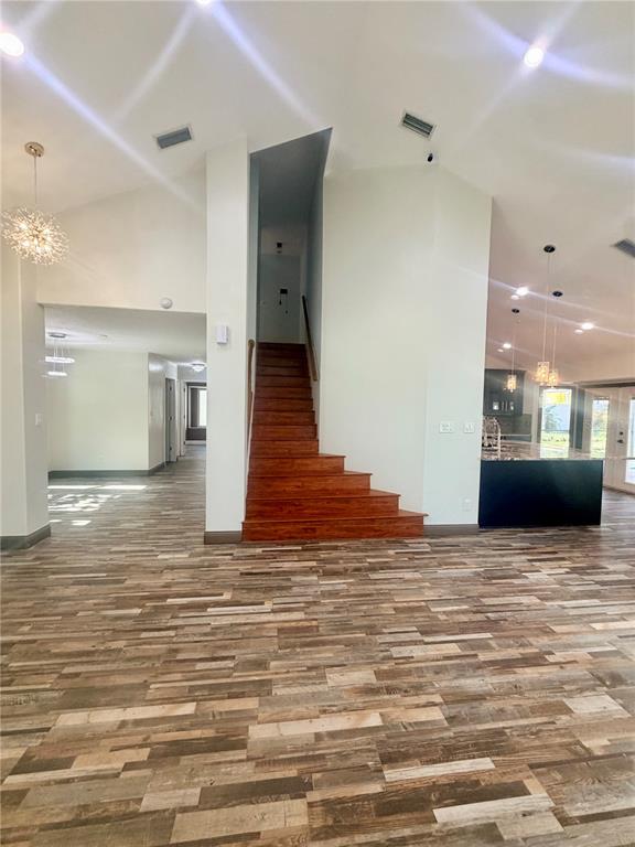 A wide-angle view shows a living area with wood-look flooring and a central wooden staircase — 14904 PERRIWINKLE PLACE, TAMPA, FL