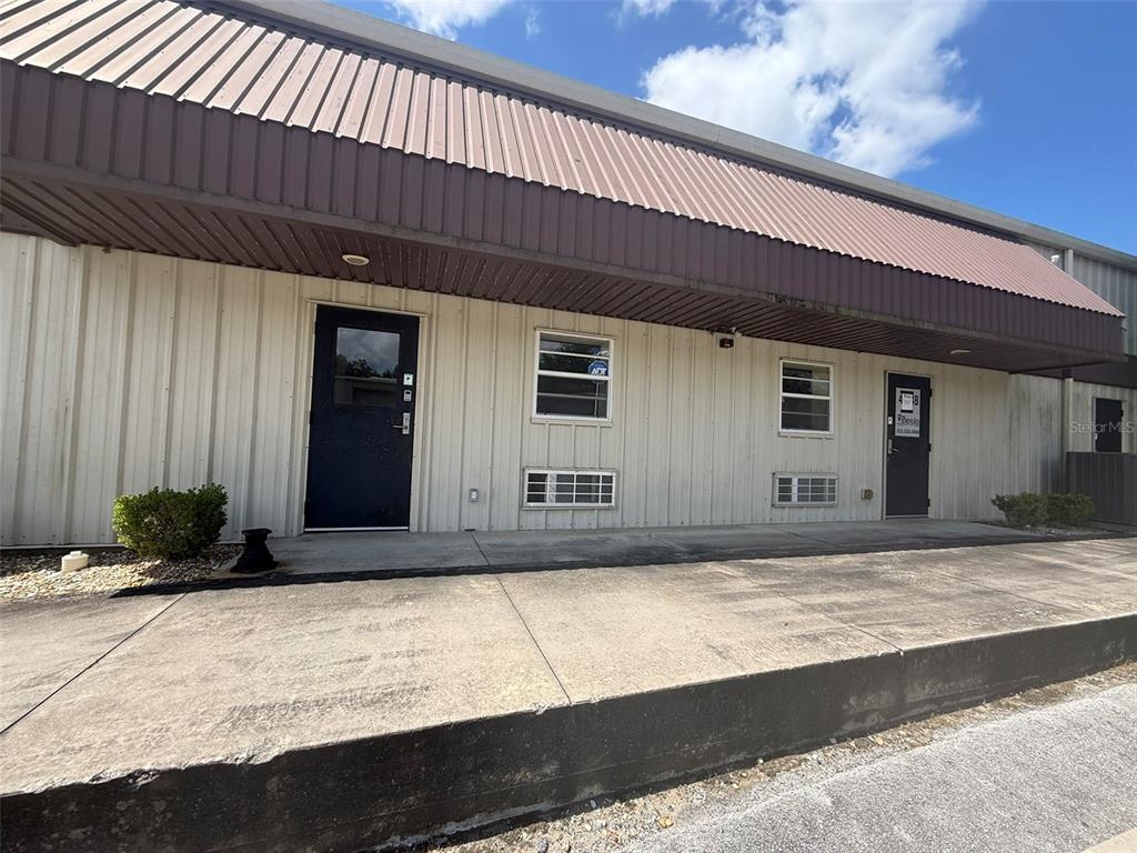 The exterior of a commercial building features two dark doors, windows, and a metal awning — 4344 SE 95TH STREET UNIT 1 & 2, OCALA, FL