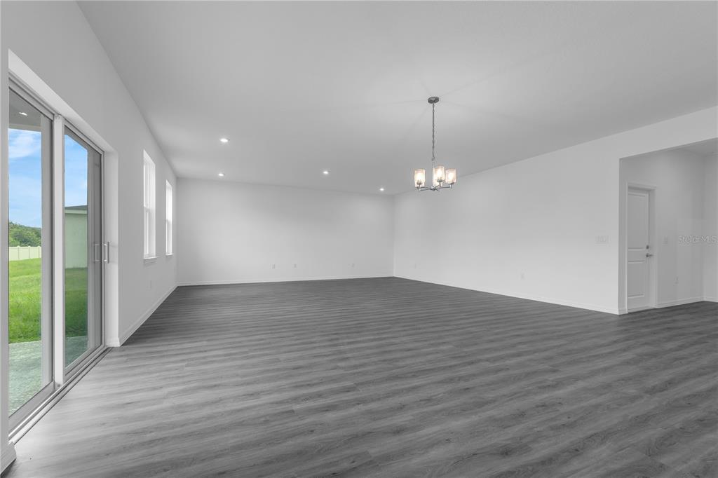 An entryway features dark wood-look flooring, a white door, and a carpeted staircase with a railing — 1342 DUNBLANE WAY NE, PALM BAY, FL