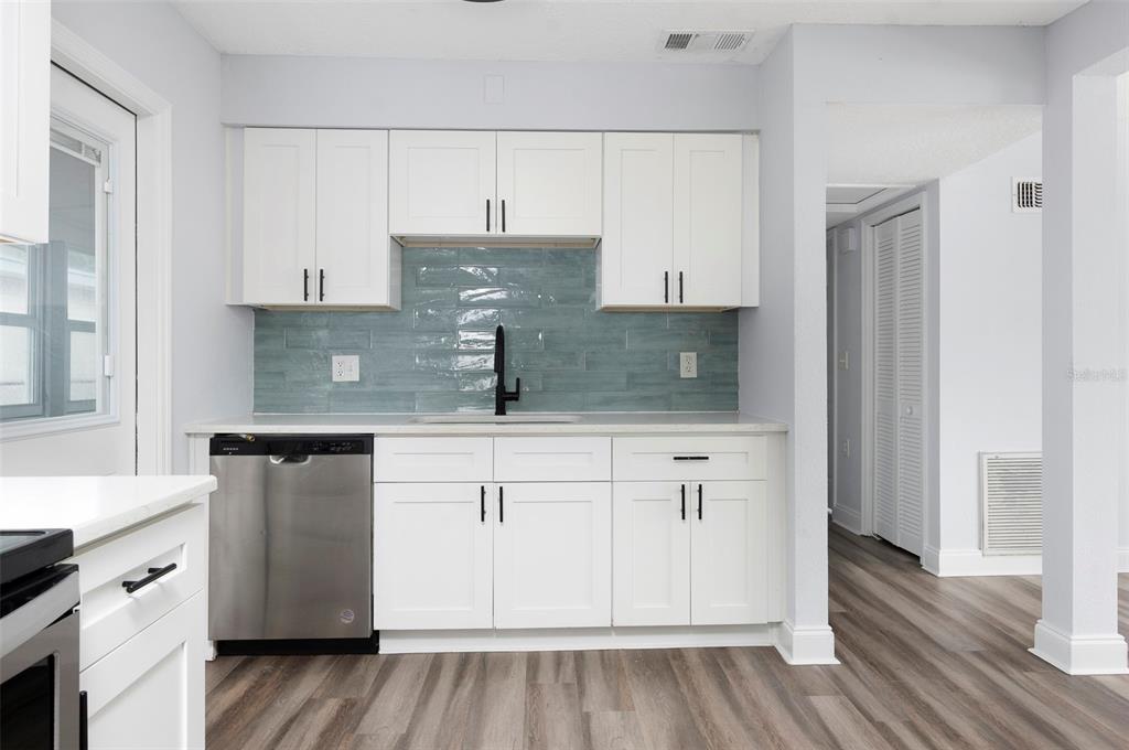 A kitchen features white shaker cabinets, a blue subway tile backsplash, and stainless steel appliances — 6929 39TH AVENUE N, ST PETERSBURG, FL