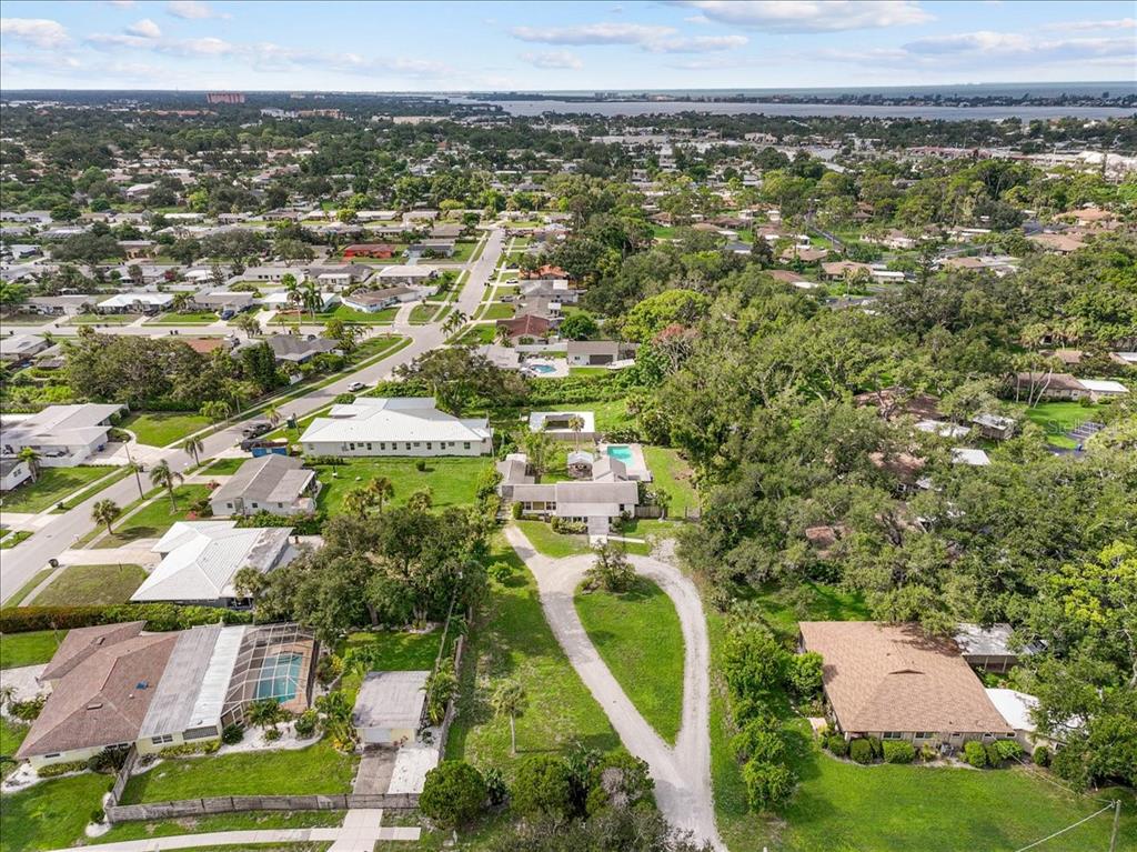 An aerial view shows a residential property with a circular driveway, pool, and surrounding neighborhood — 2404 BISPHAM ROAD, SARASOTA, FL