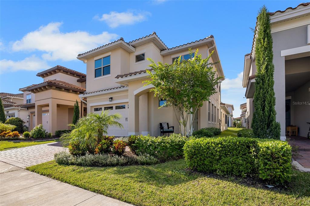 A two-story suburban house with a beige stucco exterior, a garage, and landscaped front yard — 13249 WINTERTON LANE, ORLANDO, FL