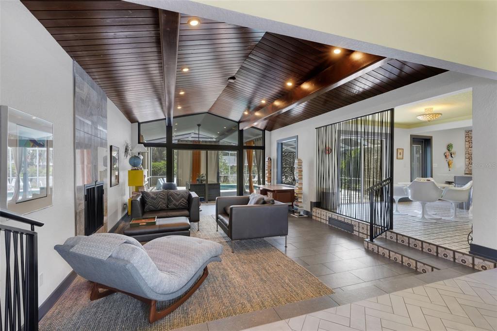 A sunken living room features a vaulted wood-paneled ceiling, fireplace, and tile flooring — 2634 COLLINS AVENUE, LAKELAND, FL