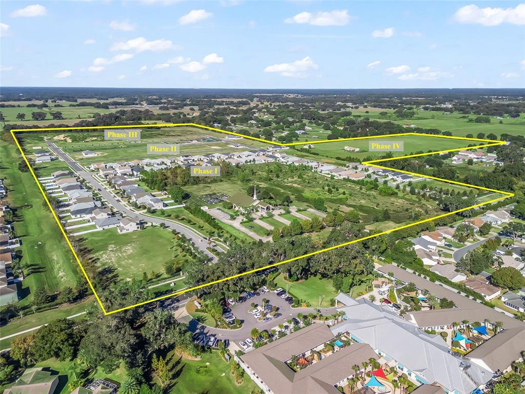An aerial view shows a residential development with four labeled phases and a church — NE 125TH LOOP, PHASE 2, OXFORD, FL