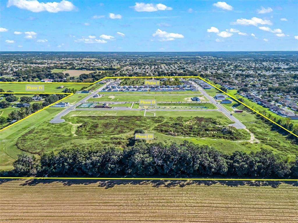 An aerial view shows a residential development site with four marked phases of land — NE 125TH LOOP, PHASE 2, OXFORD, FL