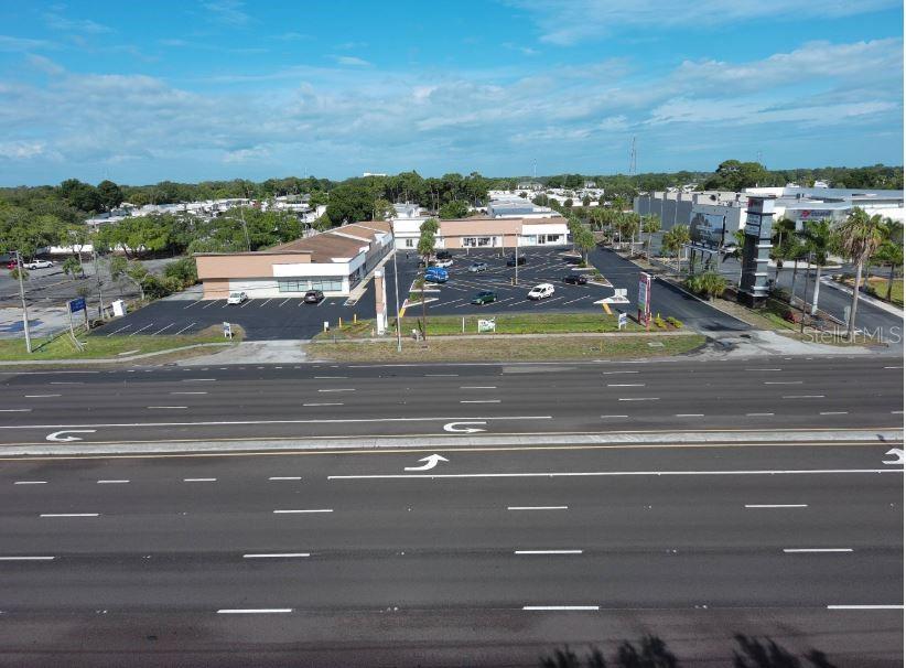 An aerial view shows a commercial strip mall with a parking lot beside a highway — 39920 US HIGHWAY 19 N UNIT 39920, TARPON SPRINGS, FL