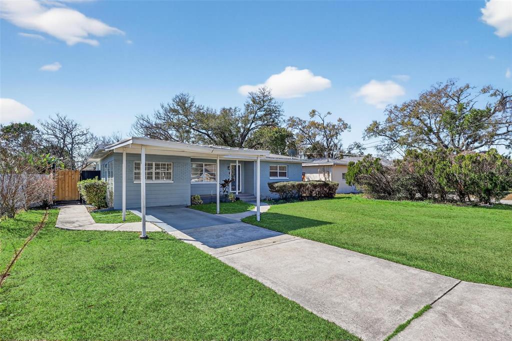A single-story house with a light blue exterior, a carport, and a concrete driveway — 2714 W GRACE STREET, TAMPA, FL