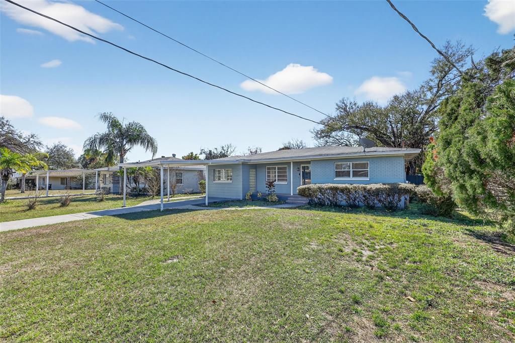 A light blue, single-story ranch-style house features a carport and a large front lawn — 2714 W GRACE STREET, TAMPA, FL