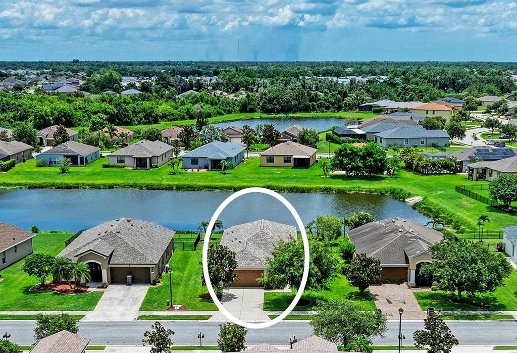 An aerial view shows a single-story house with a gray roof circled in a suburban neighborhood — 5706 106TH AVENUE E, PARRISH, FL