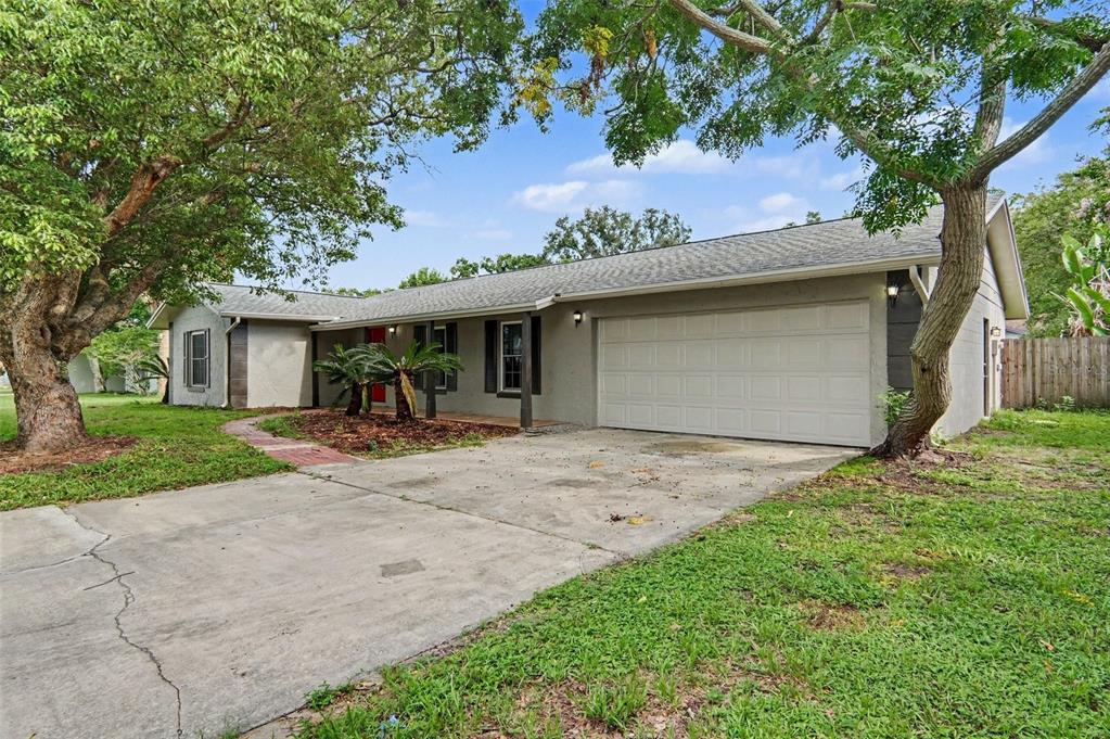 A single-story house with a gray stucco exterior, a two-car garage, and a concrete driveway — 960 APPLE LANE, ALTAMONTE SPRINGS, FL
