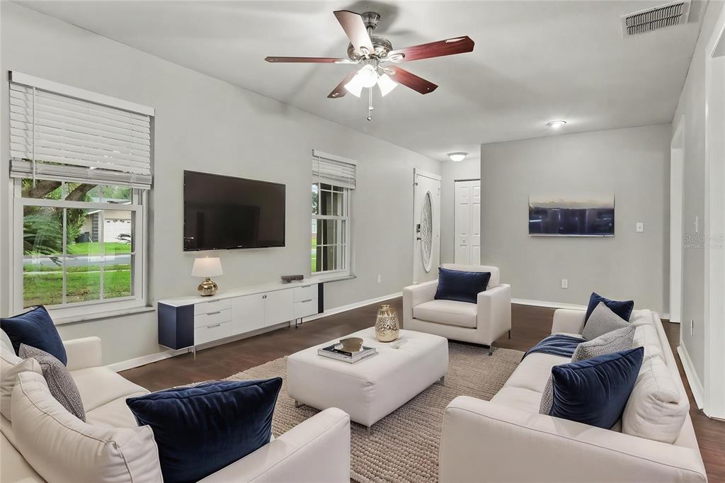 A living room features white sofas, a central ottoman, a ceiling fan, and a wall-mounted television — 960 APPLE LANE, ALTAMONTE SPRINGS, FL