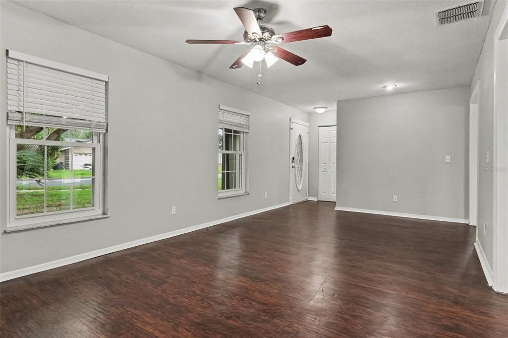 An empty living room features gray walls, dark wood-look flooring, and a ceiling fan — 960 APPLE LANE, ALTAMONTE SPRINGS, FL
