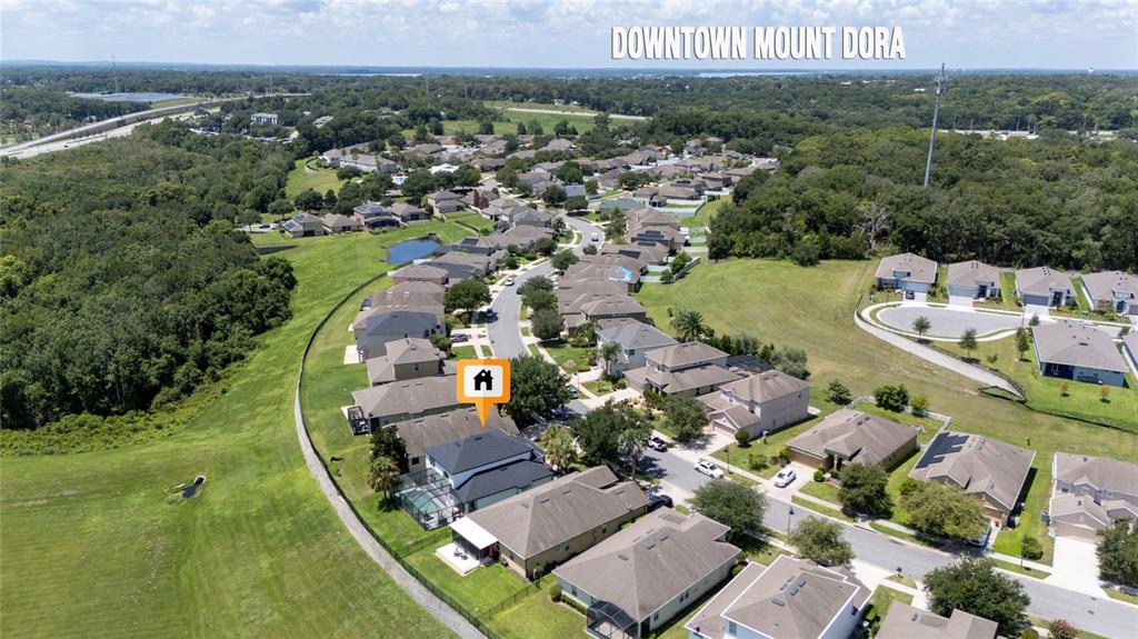 An aerial view shows a suburban neighborhood with a highlighted house and surrounding homes — 2336 NATOMA BOULEVARD, MOUNT DORA, FL