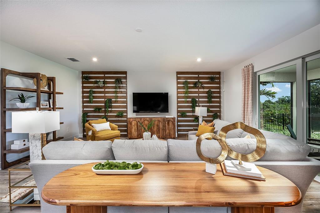 A living room features a sectional sofa, a wooden console, and two slatted wall panels — 11965 STARBRIGHT PATH, VENICE, FL