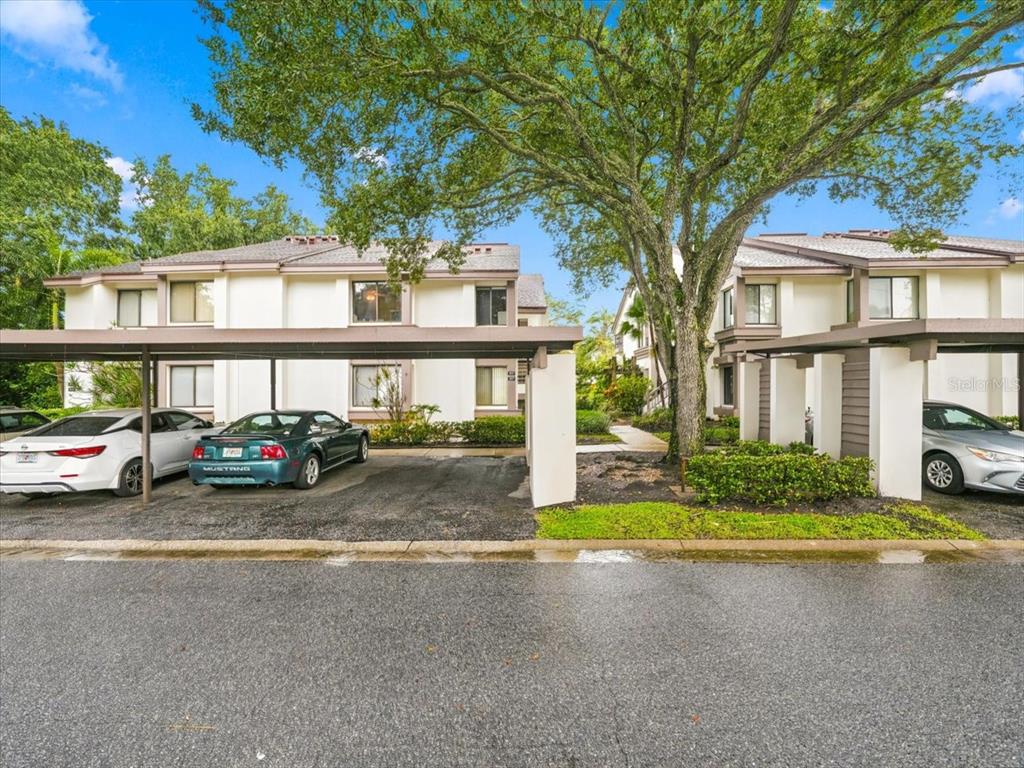 An exterior view of a white multi-story building with an outdoor staircase and brick walkway — 1816 LAKE CYPRESS DRIVE UNIT 1816, SAFETY HARBOR, FL