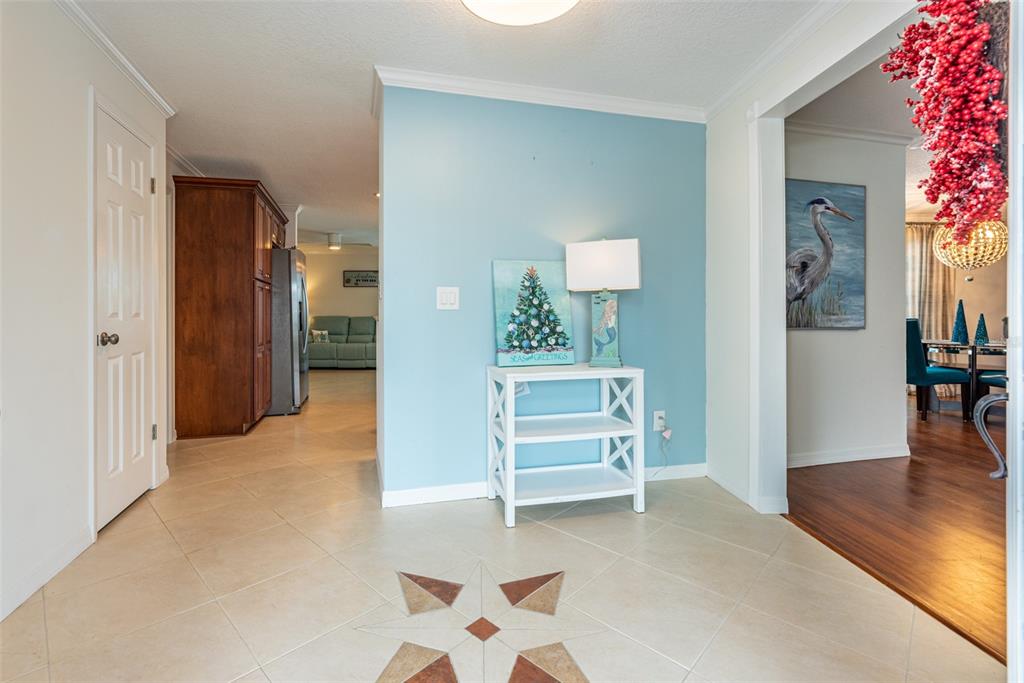 A tiled entryway features a light blue accent wall, a white console table, and decor — 910 CHIPAWAY DRIVE, APOLLO BEACH, FL