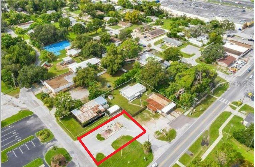 An aerial view shows a vacant, paved lot outlined in red next to residential buildings — 4650 MILE STRETCH DRIVE, HOLIDAY, FL