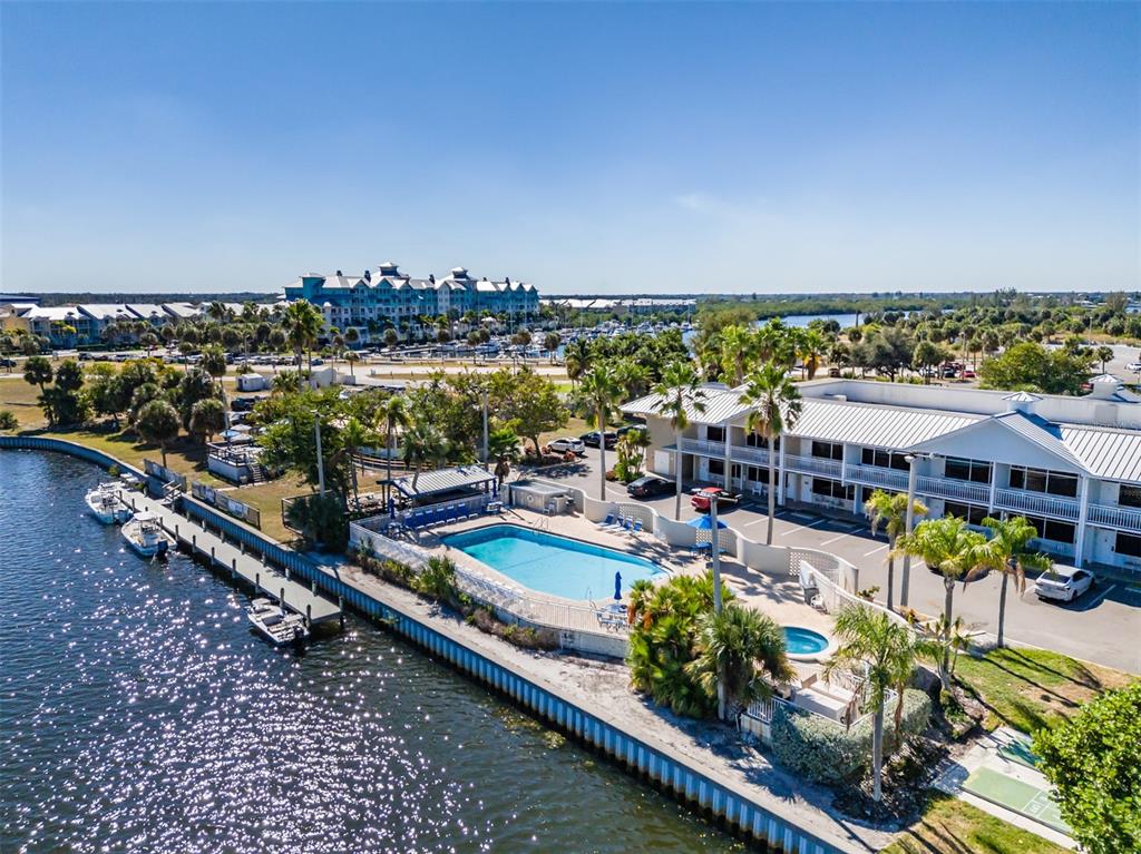 An aerial view of a waterfront hotel with a swimming pool and boat docks — 611 DESTINY DRIVE UNIT 101, RUSKIN, FL