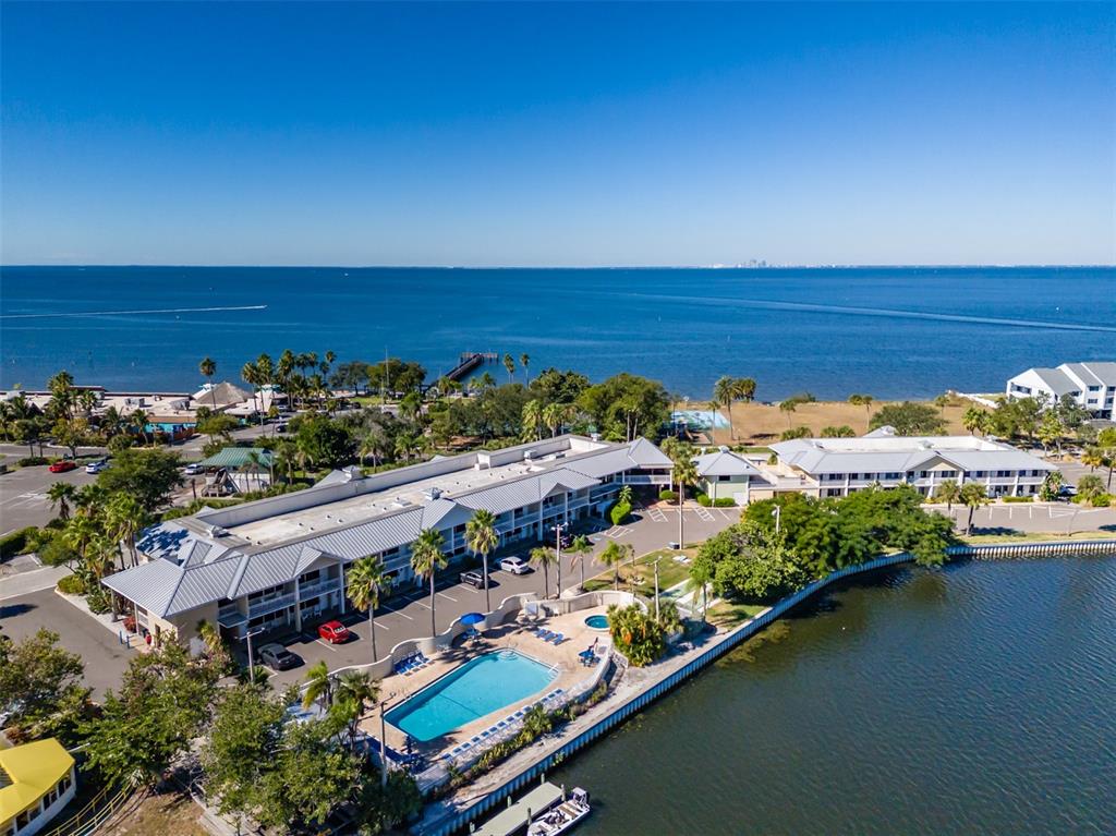 An aerial view shows a waterfront hotel with a swimming pool and parking lot — 611 DESTINY DRIVE UNIT 101, RUSKIN, FL
