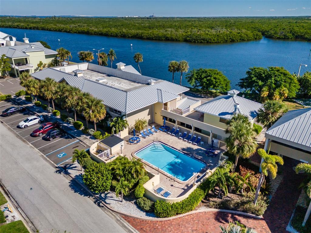 An aerial view shows a multi-story building with a swimming pool and adjacent parking lot — 611 DESTINY DRIVE UNIT 101, RUSKIN, FL