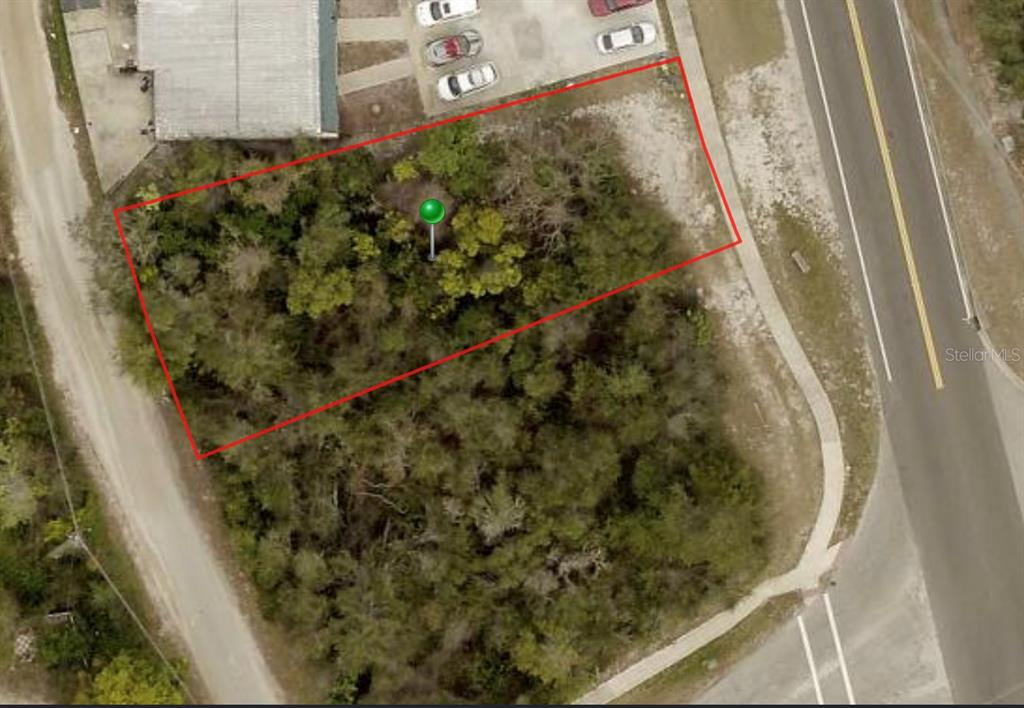 This aerial view shows a rectangular, wooded vacant lot outlined in red — 1854 PROVIDENCE BOULEVARD, DELTONA, FL