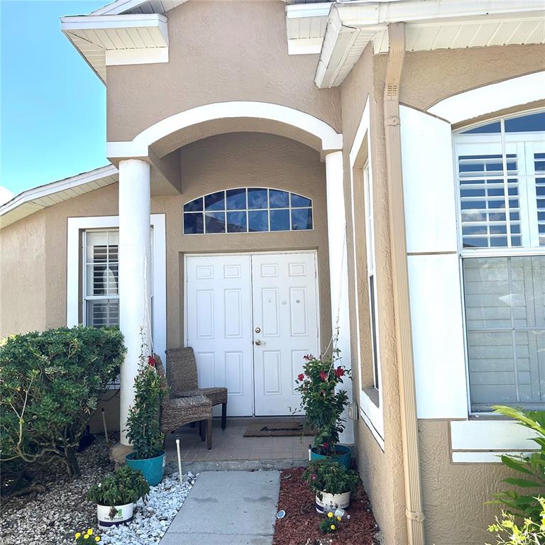 The exterior of a house features a covered entryway with double doors and white columns — 30236 LETTINGWELL CIRCLE, WESLEY CHAPEL, FL
