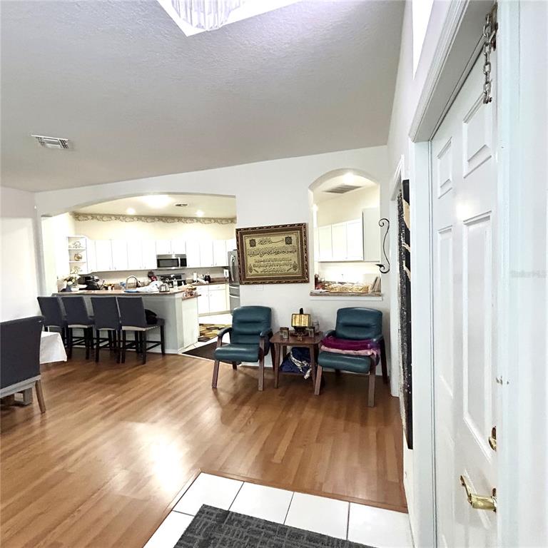 An open-concept kitchen with a breakfast bar overlooks a dining area and living space — 30236 LETTINGWELL CIRCLE, WESLEY CHAPEL, FL