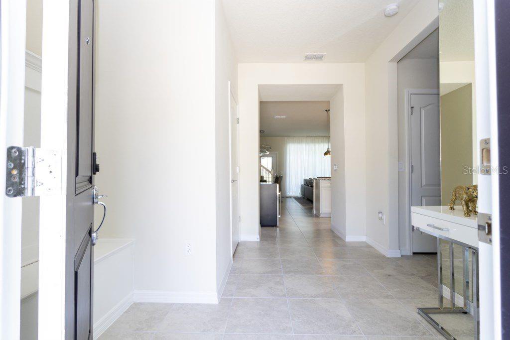 A tiled entryway leads into an open-concept living area with a white console table — 7586 OAK SPRING LANE, DAVENPORT, FL