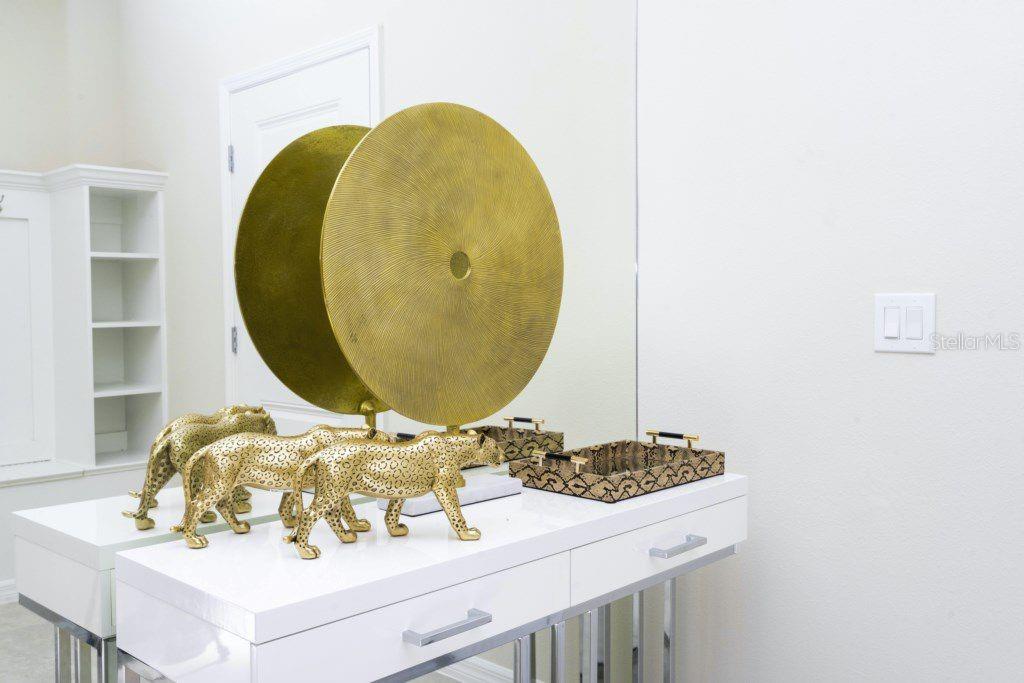 A white vanity table features gold leopard figurines and a large circular gold sculpture — 7586 OAK SPRING LANE, DAVENPORT, FL