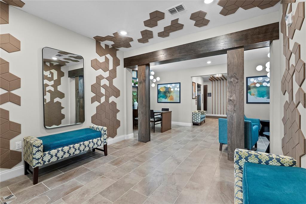 A modern lobby features a teal bench, hexagonal wall tiles, and wood-wrapped support columns — 7557 LAUREATE BOULEVARD UNIT 6401, ORLANDO, FL