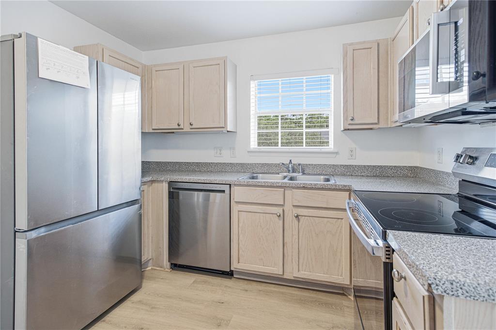 A kitchen with light wood cabinets, stainless steel appliances, and speckled granite countertops — 7800 POINT MEADOWS DRIVE UNIT 737, JACKSONVILLE, FL