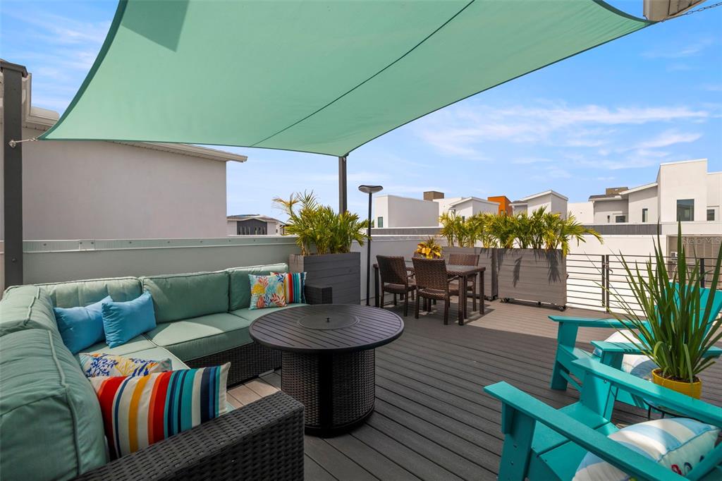 A rooftop deck features a sectional sofa, a fire pit table, dining furniture, and a shade sail — 865 S 6 AVENUE S UNIT 17, ST PETERSBURG, FL