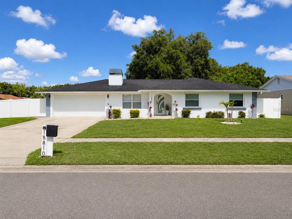 A single-story white house with a black roof and a two-car garage — 15810 SEA OATS PLACE, TAMPA, FL