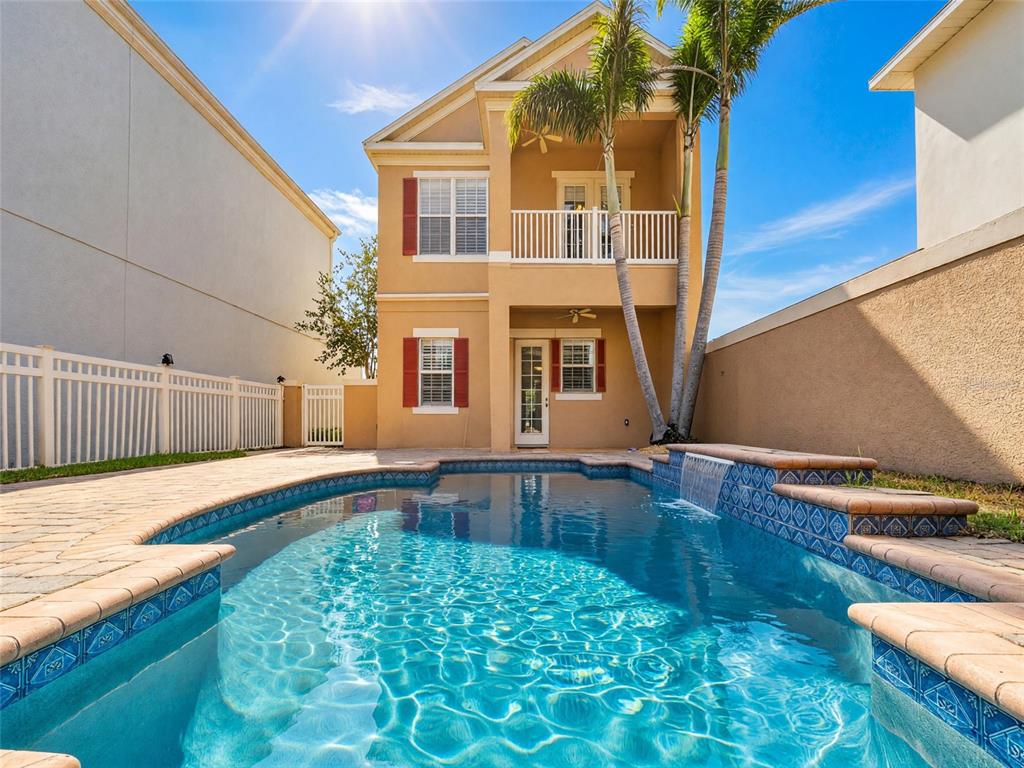 A two-story house with a tan stucco exterior, red shutters, and a two-car garage — 7526 EXCITEMENT DRIVE, REUNION, FL
