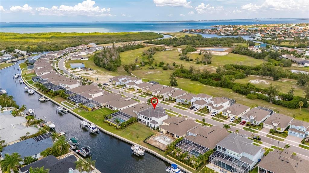 An aerial view shows a waterfront residential neighborhood with a red pin marking a house — 1016 SIGNET DRIVE, APOLLO BEACH, FL
