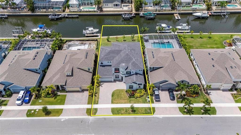 An aerial view shows a waterfront house with a pool and boat dock — 1016 SIGNET DRIVE, APOLLO BEACH, FL