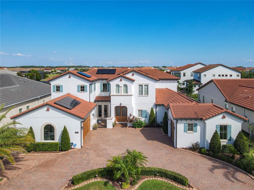 An aerial view of a two-story stucco house with a tiled roof and brick driveway — 15680 PANTHER LAKE DRIVE, WINTER GARDEN, FL