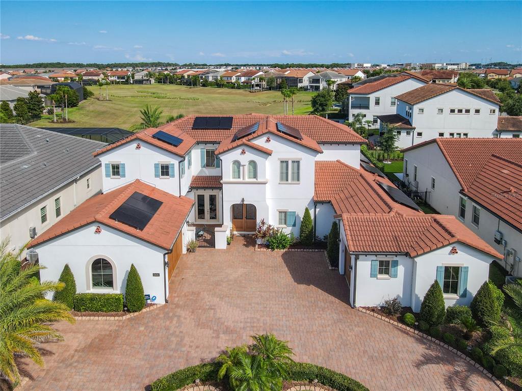 An aerial view of a two-story stucco house with a tiled roof and brick driveway — 15680 PANTHER LAKE DRIVE, WINTER GARDEN, FL